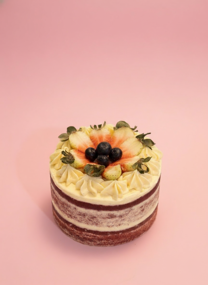 Small cake with fruit toppings on a pink background